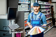 © rh2010 - Portrait of a handsome workman with color swatches near the equipment for coloring in the building shop