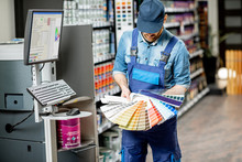 Portrait Of A Handsome Workman With Color Swatches Near The Equipment For Coloring In The Building Shop