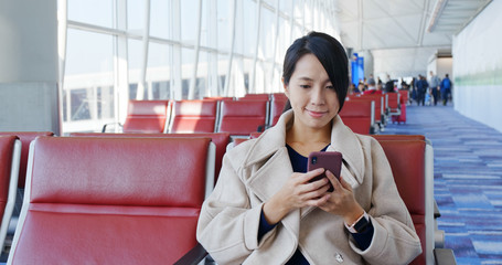 Poster - Woman look at the smart phone in the airport