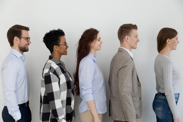 Wall Mural - Side view at happy diverse business people standing in queue