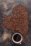Fototapeta Paryż - A cup of coffee and coffee beans poured in the form of a heart