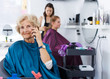 © JackF - Senior woman in barber chair with phone