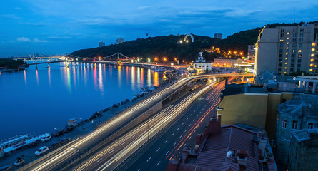 Wall Mural - Car light trails and urban landscape. Moving car with blur light through city at night. Kiev