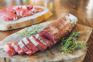 Raw and fresh beef steak rib eye sliced sirloin meat on wooden table in restaurant.