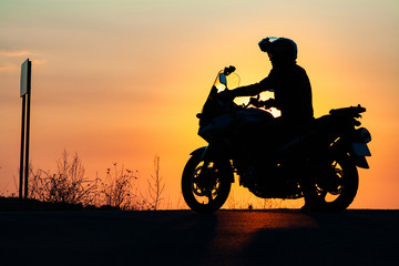 man on his motorbike riding into sunset