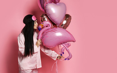 Valentine Beauty girl hold red and pink air balloons blow kiss on pink background celebrating Valentines Day