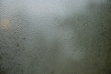 Stream drops on window glass  abstract background