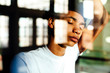 © Carlos David - Portrait of a young man with eyes closed, standing against large windows