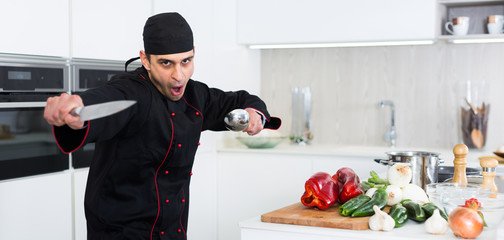 Wall Mural - Portrait of the man proffesional who is posing with devices in the kitchen