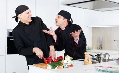 Wall Mural - Men professionals are cooking salad with emotions in the kitchen