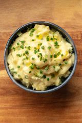 Wall Mural - Pomme puree, an overhead photo of a bowl of potato puree with herbs, shot from the top on a rustic background with a place for text