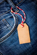 Mock up of empty brown paper price tag on blue jeans