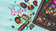 Chocolate and quail eggs, bunnies and color dragee in vintage wooden box with pink text of easter