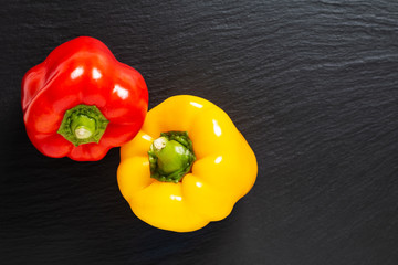 Background for food product 3 colors red green and yellow of organic Bell pepper or parpika on black slate board