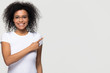 © fizkes - Smiling african woman in glasses advertising pointing finger at copyspace