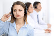 © rogerphoto - Call center operators. Focus on young cheerful smiling woman in headset. Business and customer service concepts