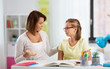 © Syda Productions - education, family and learning concept - displeased mother talking to daughter while doing homework at home