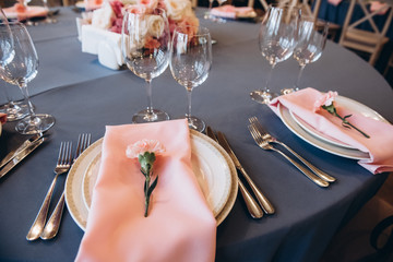 Wedding. Banquet. Served banquet table, stylishly decorated with beautiful pastel-pink carnations on plates and pastel pink napkins