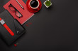 Black background red coffee cup notepad alarm clock flower diary scores keyboard on the table. Top view with copy space