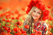 Portrait of a girl on the street with a wreath of poppy flowers on the head