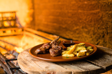 Wall Mural - fried ribs with potatoes and gravy on a clay plate