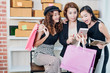 © Yingyaipumi - Beautiful girls are holding shopping bags, using a smart phone and smiling.shopping online concept.