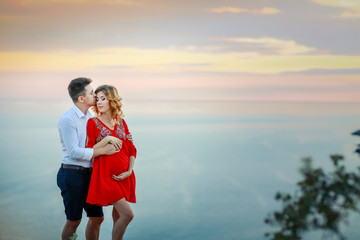 Couple family traveling together on cliff edge in Norway man and woman lifestyle concept summer vacations outdoor aerial view Lofoten islands Reinebringen mountain top