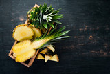 Pineapple. Sliced pineapple on a wooden background. Top view. Free copy space.