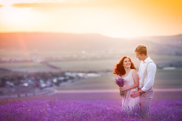 Wall Mural - Young couple in love bride and groom, wedding day in summer. Enjoy a moment of happiness and love in a lavender field. Bride in a luxurious wedding dress.