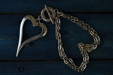 Silver heart on a chain on a wooden background