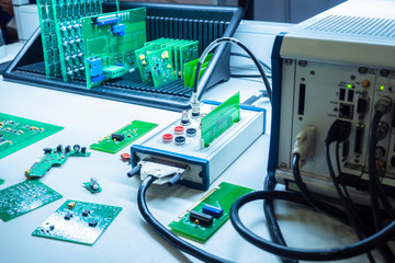 Poster - Electronic components under test. ICs. Plant for the production of electronics. Electronic cards are on the table. Check the quality of the chips. Work place.