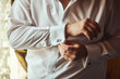 © Yuliia - businessman dresses white shirt, male hands closeup,groom getting ready in the morning before wedding ceremony. Men Fashion