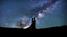 Silhouette Of Young Couple On A Milky Way Stars Background. Valentine's Day Concept. 