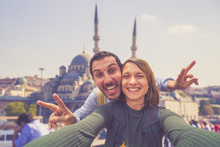 Happy Young Couple Taking A Selfie Photo In Istanbul, Turkey. Two Smiling Tourists With Smart Phone Taking Selfie In Front Of The Blue Mosque In Istanbul. Travel And Vacation Around Concept 
