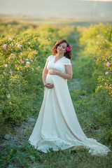 Wall Mural - Outdoor natural portrait of beautiful pregnant woman in white dress