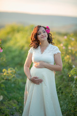 Wall Mural - Outdoor natural portrait of beautiful pregnant woman in white dress