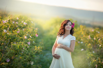 Wall Mural - Outdoor natural portrait of beautiful pregnant woman in white dress