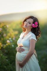 Wall Mural - Outdoor natural portrait of beautiful pregnant woman in white dress