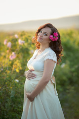 Wall Mural - Outdoor natural portrait of beautiful pregnant woman in white dress