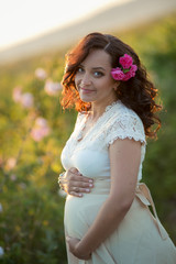 Wall Mural - Outdoor natural portrait of beautiful pregnant woman in white dress