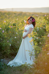 Wall Mural - Outdoor natural portrait of beautiful pregnant woman in white dress