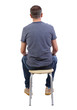 Back view of a man sitting on a chair.