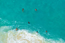 BALI, INDONESIA - 3rd FEB 2019; Aerial View Of People Swimming In The Transparent Turquoise Sea Over Sunny Day At Kelingking Beach. Top View From Cliff.