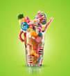 Monster shake, freak caramel shake isolated. Colourful, festive milk shake cocktail with sweets, jelly. Colored caramel milkshake array of different childs sweets and treats in glass on white