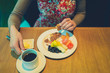 © LoloStock - Young woman having breakfast in hotel