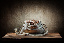 Burlap Bag Of Coffee Beans On Vintage Wood