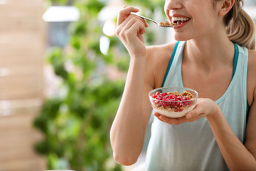 Canvas Print - Young woman in fitness clothes having healthy breakfast at home, closeup. Space for text