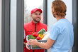 © New Africa - Courier giving plastic crate with products to customer at home. Food delivery service