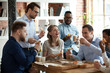 © fizkes - Happy diverse team people talking laughing eating pizza in office