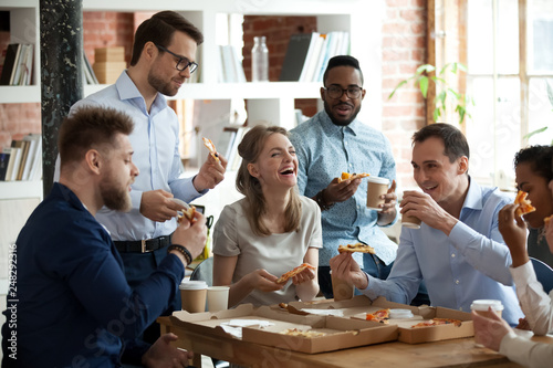 Fotografía Happy diverse team people talking laughing eating pizza in office